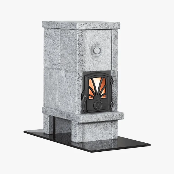 Norsk Kleber Otta 102 är en grå murad stenvärmare med en dekorativ svart metalldörr som visar en varm orange glöd inuti, placerad på en svart rektangulär bas mot en vit bakgrund.