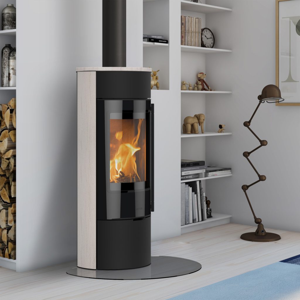 Lotus Kaminer: En guide till funktion & design 6 En modern Lotus-vedspis med glasdörr visar en eld som brinner inuti. Den står i ett ljust vardagsrum bredvid inbyggda hyllor och en stapel ved, med en unik lampa och dekorativa föremål i närheten.