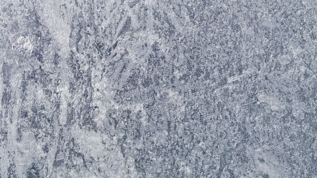 Grov, strukturerad grå stenyta med marmorerade mönster och fläckar av ljusare och mörkare nyanser - perfekt för dig som vill rengöra täljsten och behålla dess naturliga skönhet.