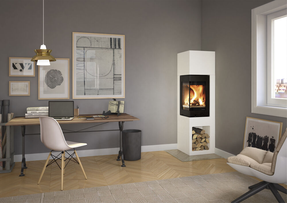 Ett modernt hemmakontor med skrivbord i trä, laptop, stol, väggkonst och en vit murspis med staplad ved. En rund stol med kudde sitter nära ett fönster som släpper in naturligt ljus.