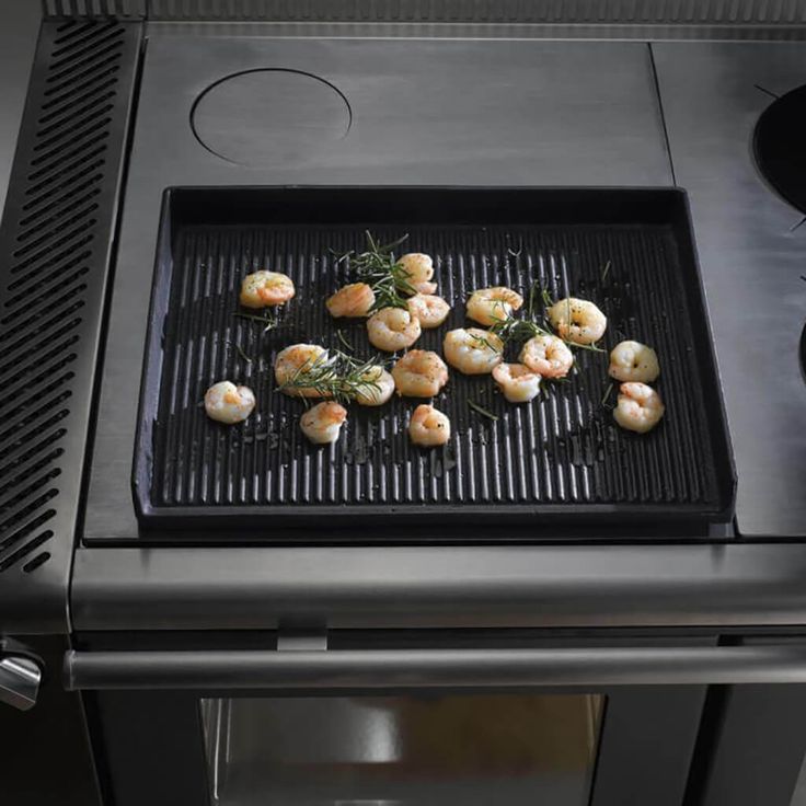 Stekhäll med räkor på en wamsler vedspis som symboliserar matlagnings kapaciteten