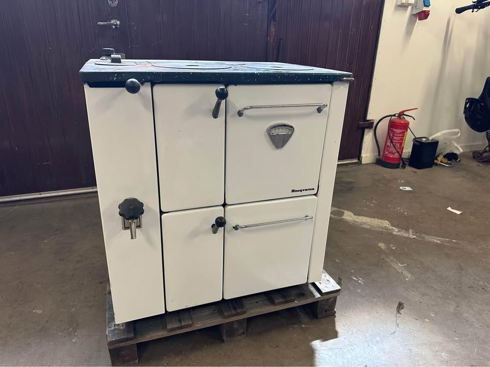 Vedspisen Husqvarna 3026 som står i lagerlokal på en pall.